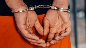 Hombre detenido asegurado con esposas en las manos.