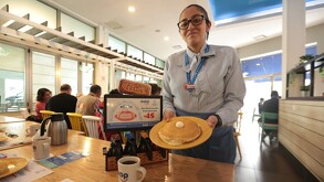 Mesera de IHop entrega pancakes.