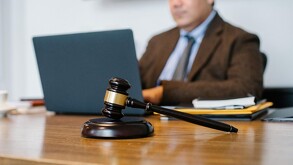 Oficina de un juez con una persona sentada junto a un escritorio.