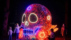 Niños aprecian un espectáculo de luces relativo al día de muertos en el Glow Fest en Europa