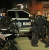 Oficiales alrededor de una patrulla de la Policía Municipal de Zapopan y moto patrullas al exterior de una zona de viviendas durante la noche