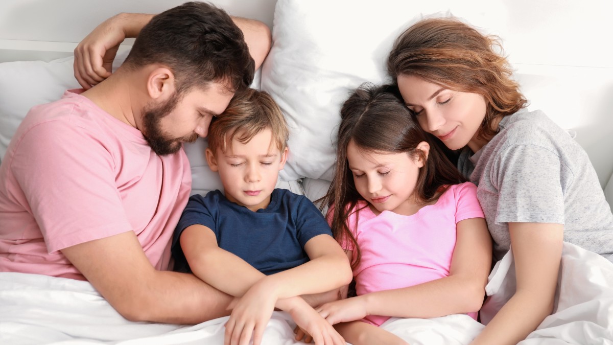 Familia de 4 personas descansando en una cama