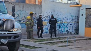 Dos oficiales de la Policía Municipal de Tlajomulco junto a dos elementos de Protección Civil y Bomberos al exterior de un callejón acordonado