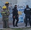 Dos oficiales de la Policía Municipal de Tlajomulco junto a dos elementos de Protección Civil y Bomberos al exterior de un callejón acordonado