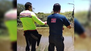 Guardavidas y bomberos de Ayotlán vistos de espaladas a las orillas del Río Lerma en Jalisco