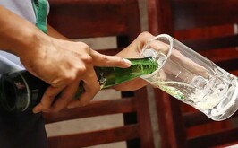 Persona sirviéndose una botella de cerveza en un vaso.