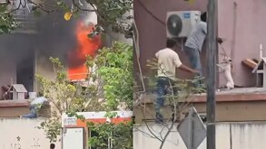 Personas brincando una barda para ayduar a un perro atrapado en un incendio.