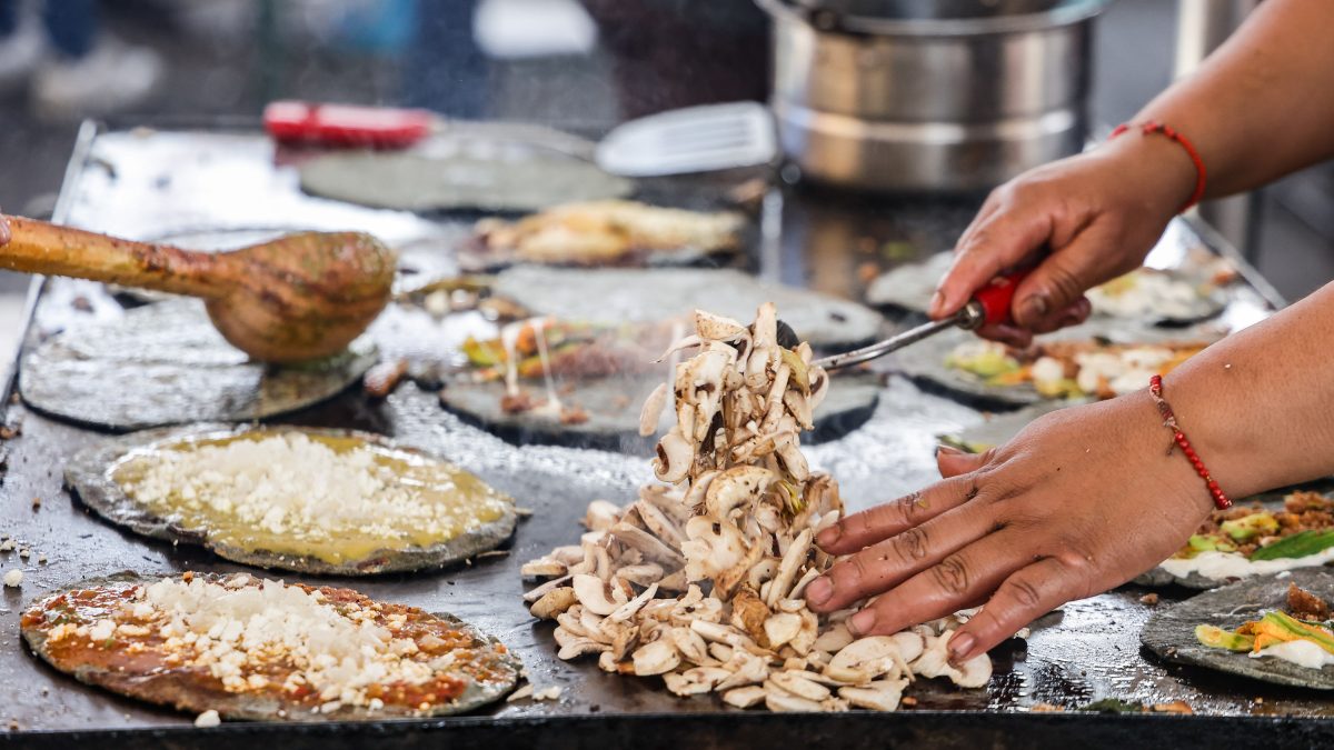 una mujer cocinando en un comal gorditas poblanas