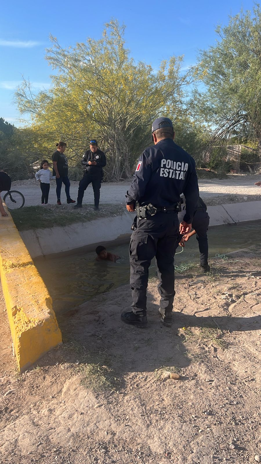 Niño sacando a perrito con ayuda de oficiales