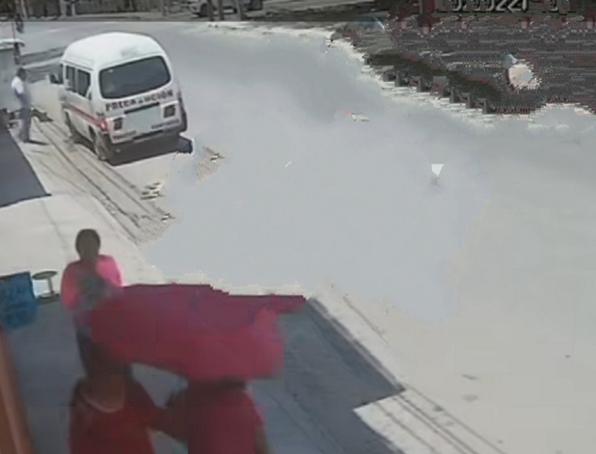 Hombre parado a un costado de su combi del transporte público.