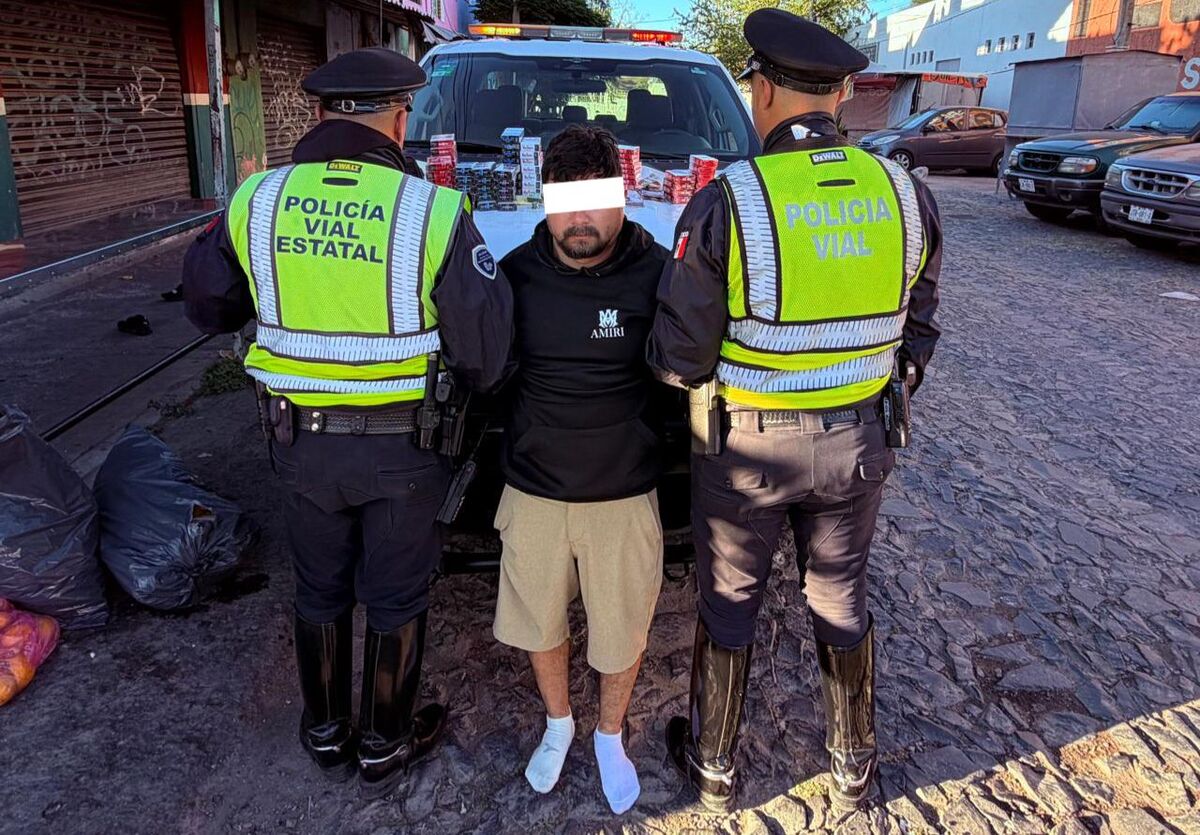 Hombre detenido con policías a los ladospOLICÍA DE gUADALAJARA, BILLETES FALSOS