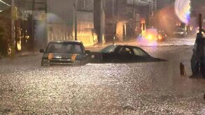 Dos autos sumergidos en el agua en una calle inundada.
