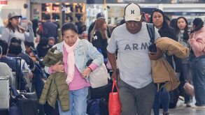Personas adultas caminan mirando hacia abajo en una terminal de autobuses.