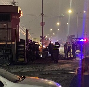 Se observa a varias personas paradas, es de noche y hay un choque.