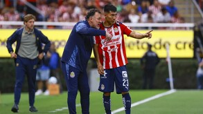 Director Técnico de las Chivas, Gabriel Milito, sostenido del hombro al centrocampista Daniel Aguirre en medio de una cancha de fútbol