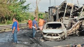Automóvil destruido por el fuego del accidente, personas alrededor observando los daños en la autopista de Veracruz