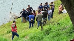Personas alrededor de una presa en la búsqueda de una persona desaparecida.