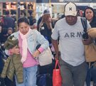 Personas adultas caminan mirando hacia abajo en una terminal de autobuses.