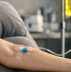 Brazo de persona canalizada recibiendo vía intravenosa sueros vitaminados