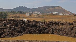 Laguna de agua negra formada en un campo de cultivo de Puebla.
