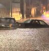 Dos autos sumergidos en el agua en una calle inundada.