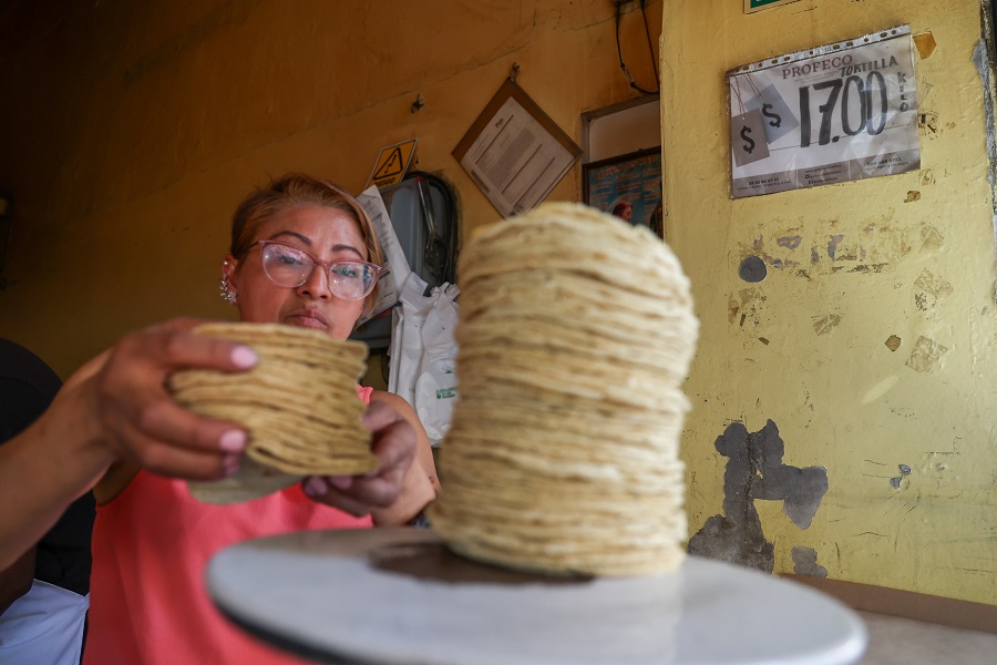 Mujer acomodando tortillas en una báscula para ponerlas a la venta.