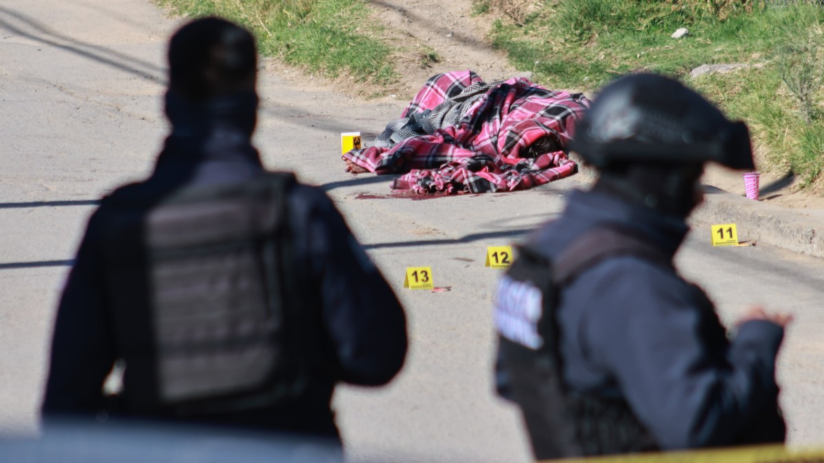 un cuerpo cubierto con una cobija en una calle de amozoc