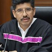Hombre con toga de ministro habla desde una tribuna.