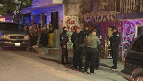 Se observa a varias personas afuera de una casa, es de noche.