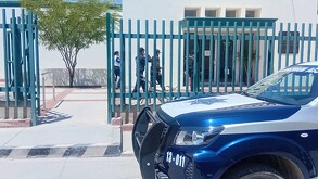 Edificio blanco con rejas verdes y patrulla de Gómez Palacio