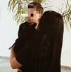 Joven mujer con vestido negro cargando un bebé