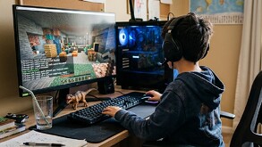 Niño frente a una computadora con una sudadera negra