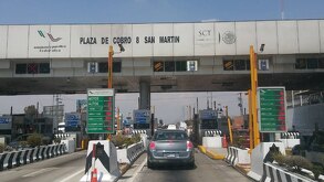Automovilistas circulan por las casetas de cobro de Puebla y al frente la lista de los precios