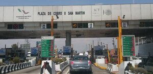 Automovilistas circulan por las casetas de cobro de Puebla y al frente la lista de los precios