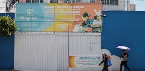Personas caminando en la entrada del colegio Carrusel Magone en Puebla.