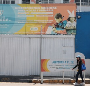 Personas caminando en la entrada del colegio Carrusel Magone en Puebla.