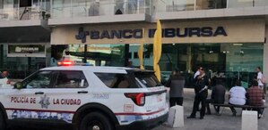 Patrulla de policía afuera de una sucursal de banco Inbursa en Puebla.