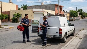 Se observa a un hombre y mujer en la vía pública, hay una camioneta blanca a lado.