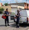 Se observa a un hombre y mujer en la vía pública, hay una camioneta blanca a lado.