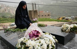 Malak Meslmani, madre de Jawad Younes, de 11 años, asesinado el 27 de marzo de 2026 en un ataque aéreo israelí, visita la tumba de su hijo.