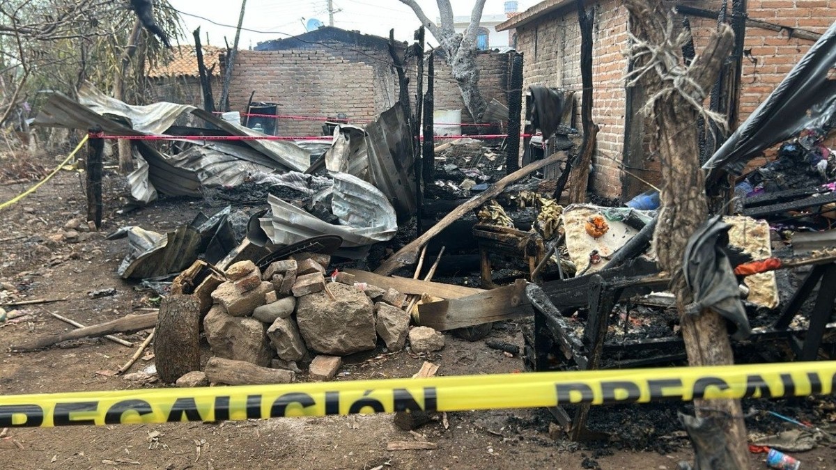 Láminas, piedras y muebles calcinados dentro de un área acordonada por cintas policiacas dentro de una vivienda