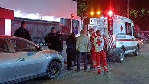 Paramédicos de la Cruz Roja junto con policías de Guadalajara y un hombre parados junto a una ambulancia con las puertas abiertas