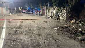 una patrulla en una calle de terracería donde ocurrió un asesinato