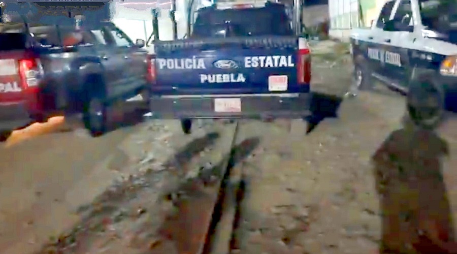 Patrulla de la policía estatal de Puebla estacionada en un campo de futbol.