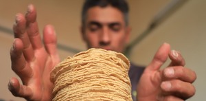 Hombre apila tortillas de maíz en México.