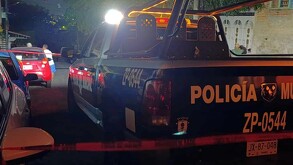 Vista de la parte trasera de una patrulla de la Policía Municipal de Zapopan dentro de un área acordonada con autor y personas alrededor