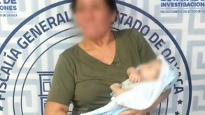 Mujer de la tercera edad cargando a un bebé rescatado.