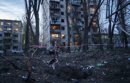 Una mujer pasea con un perro entre los escombros de una casa dañada en un ataque ruso a una zona residencial en Kiev, Ucrania, el 16 de abril de 2026.