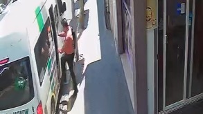 Hombe de camisa naranja y mochila al hombre sube a un transporte colectivo.