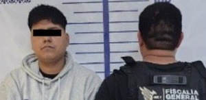 Hombre con los ojos cubiertos junto a un policía.